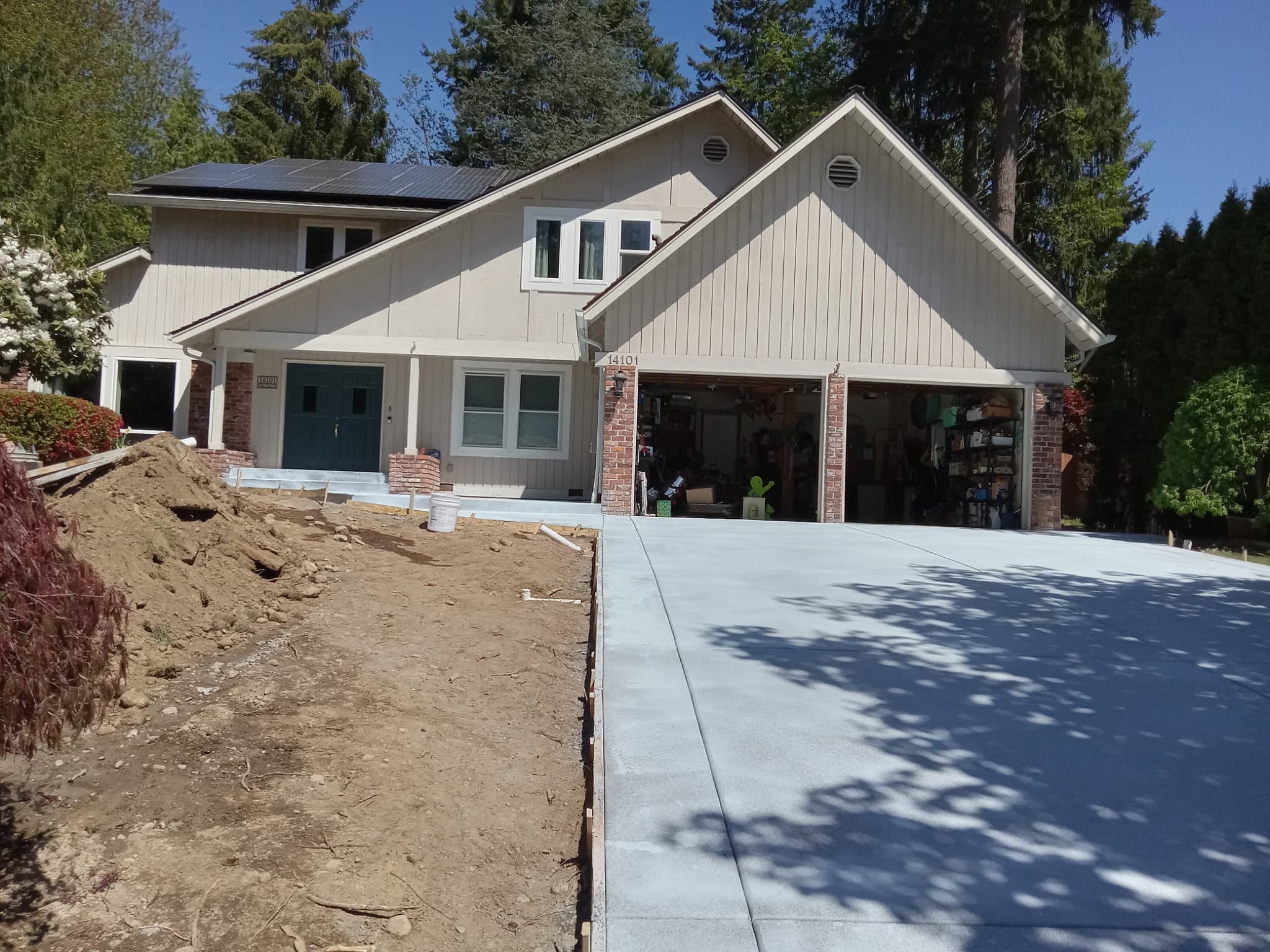 Wide view of finished concrete driveway at Pacific Northwest home with solar panels