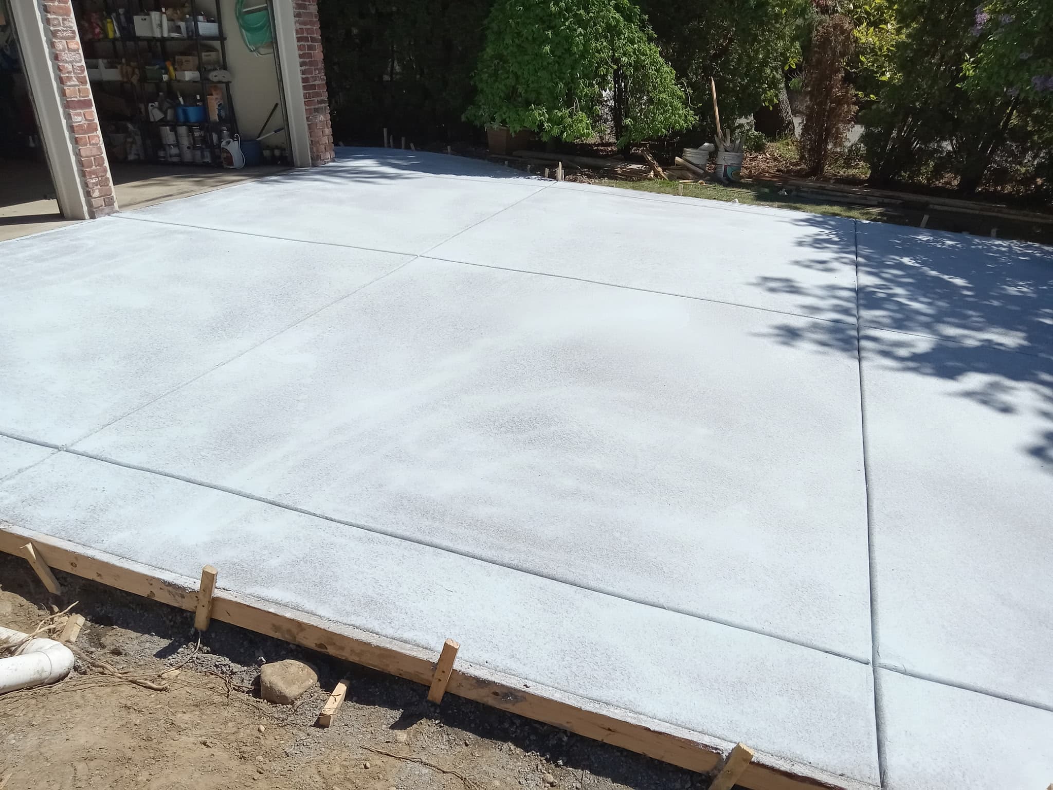 Wide smooth concrete driveway freshly finished with form boards