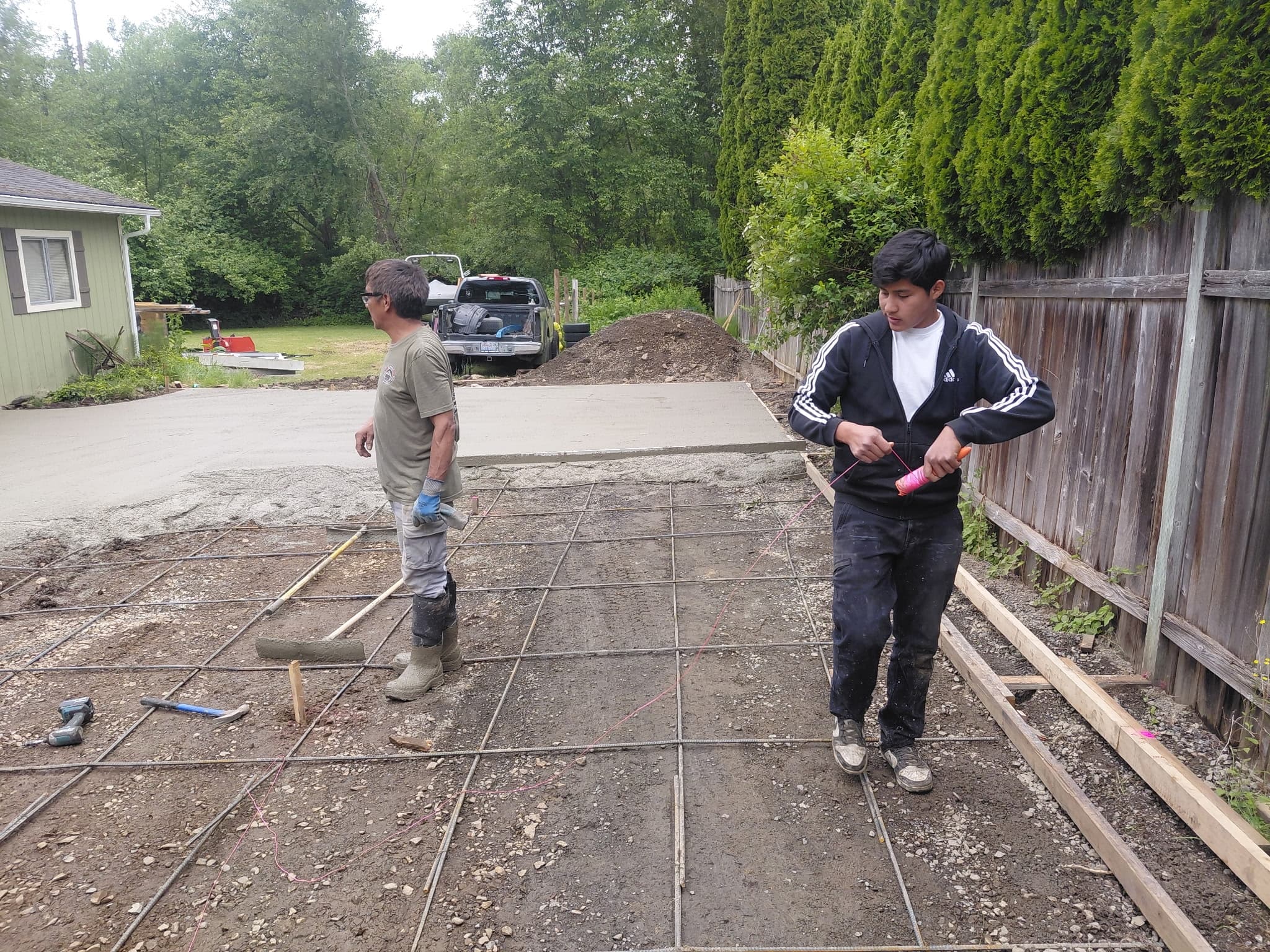 Crew setting rebar grid before a residential concrete pour