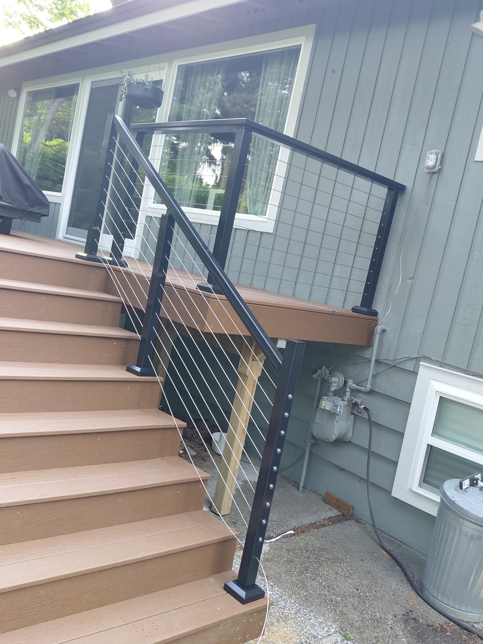 Side view of composite deck stairs with black cable railing system