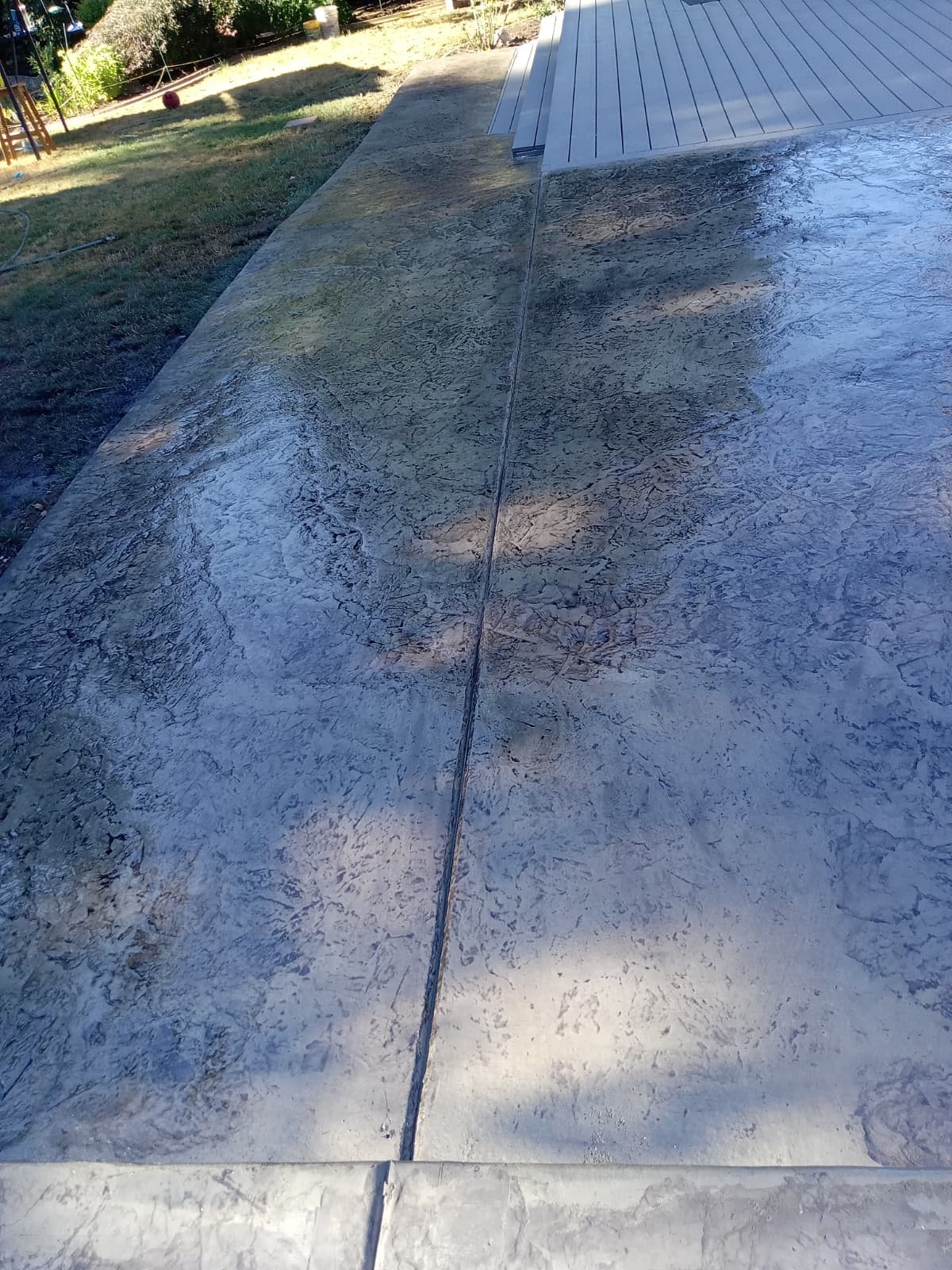 Stamped concrete surface adjacent to composite deck boards