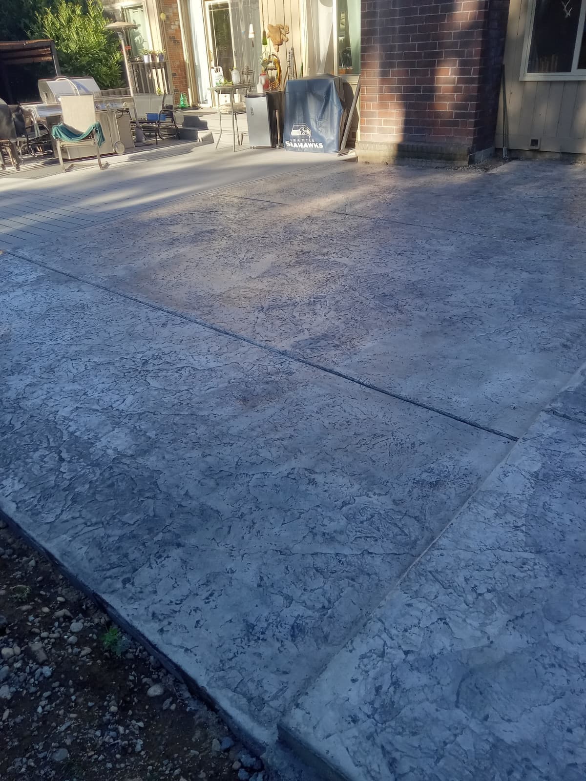 Finished stamped concrete patio with textured surface next to home